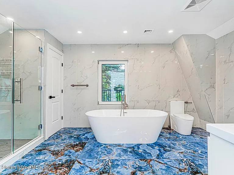 Calacatta marble bath with blue agate floor and freestanding tub