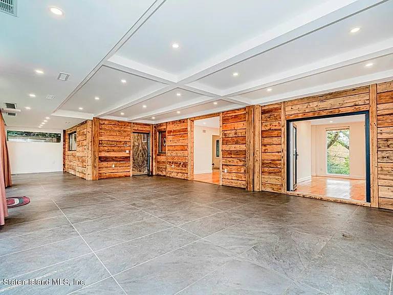 Coffered ceiling living hall with reclaimed wood walls