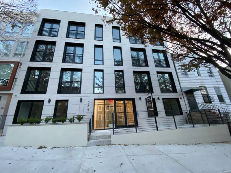Four-story white multi-family with Juliet balconies