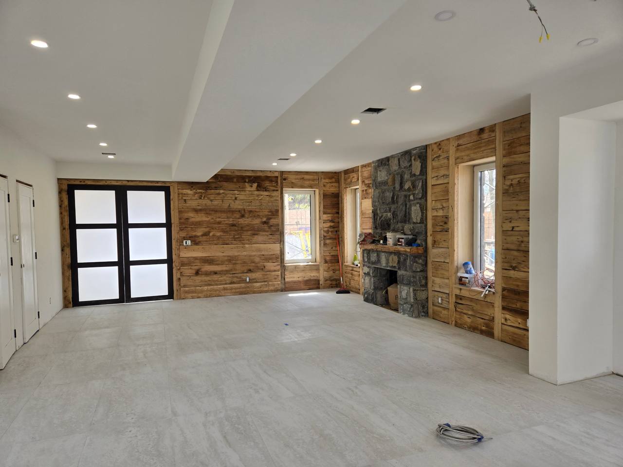 Wood-clad open living with stacked stone hearth